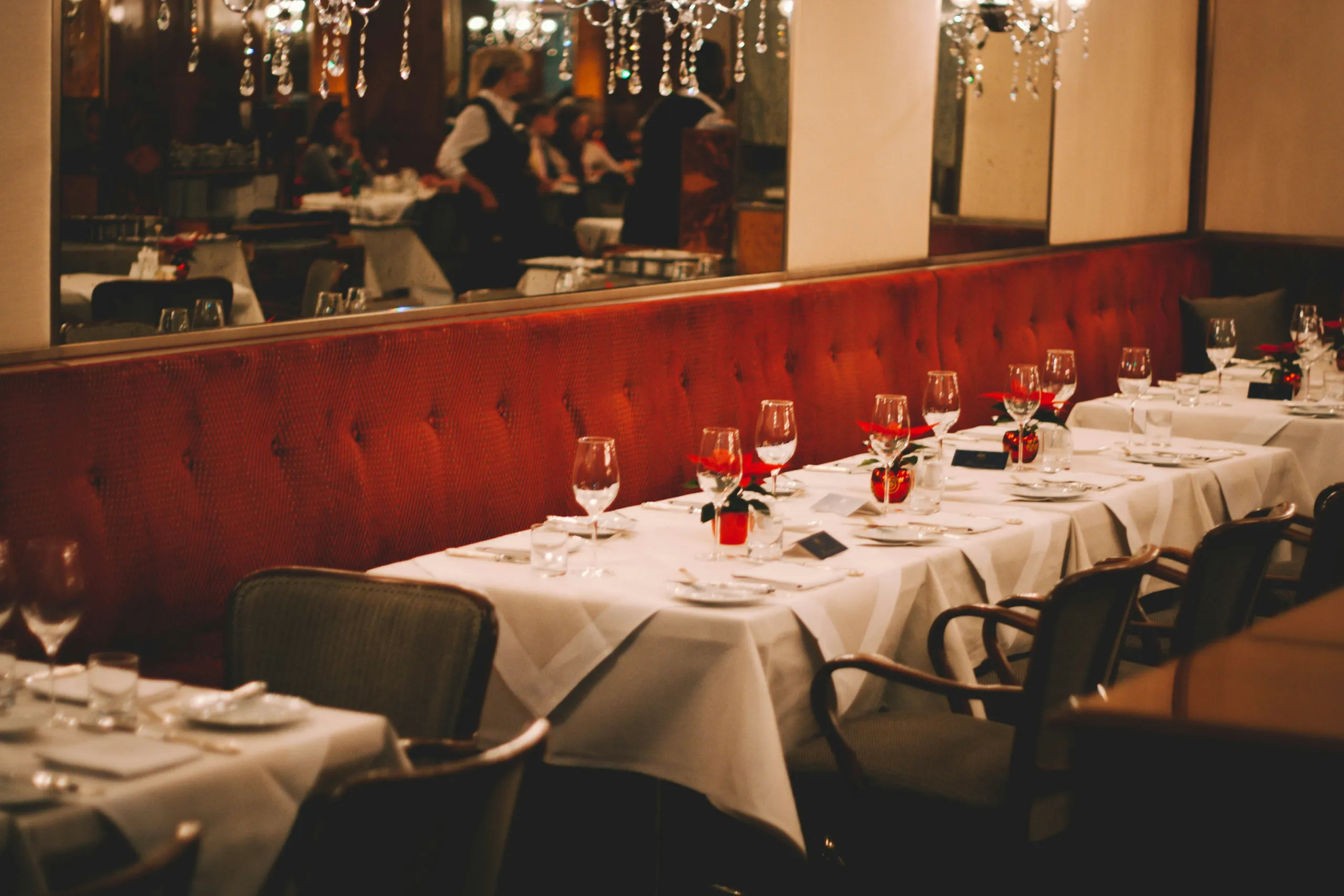 Salón de banquetes decorado para una celebración, largas mesas en blanco