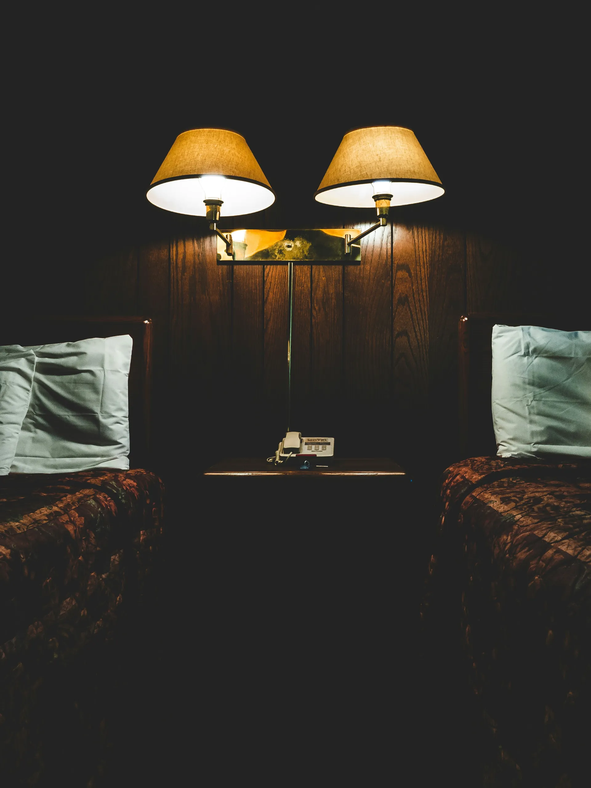 Acogedora habitación con dos camas de madera y una ventana luminosa